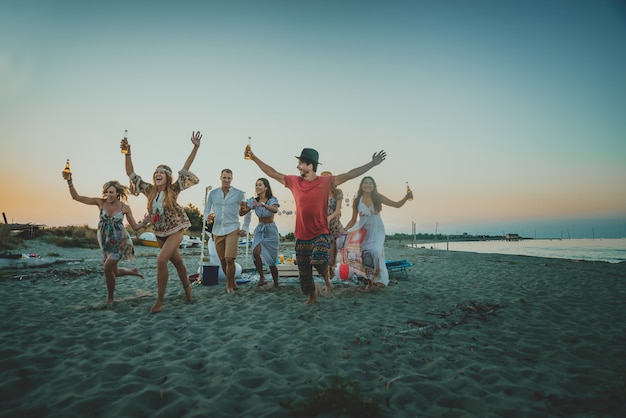 Groep vrienden feesten op het strand