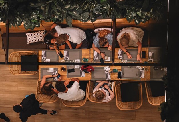 Groep vrienden genieten van diner bij een barbecue van bovenaf gezien