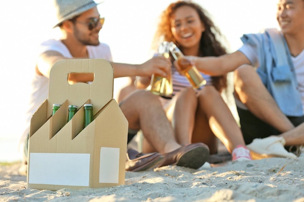 Groep vrienden hangen met bier op het strand