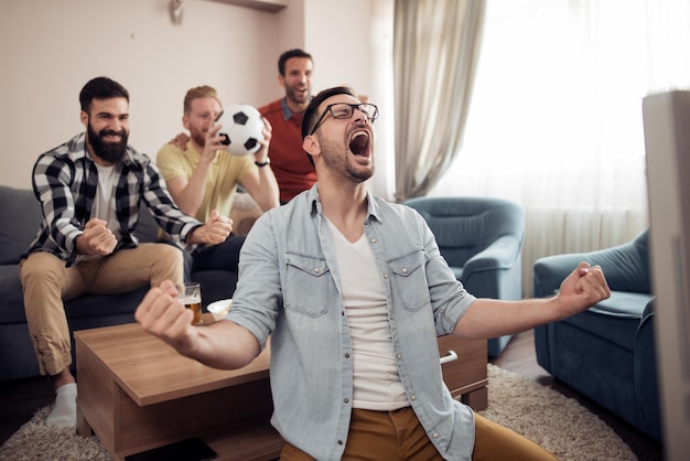 Groep vrienden kijken samen naar voetbalwedstrijd