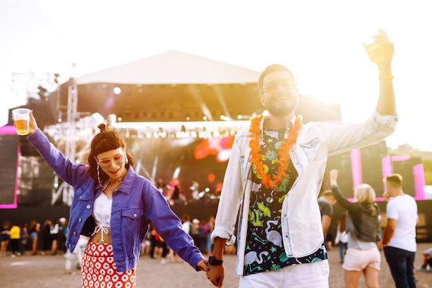 Groep vrienden met bier dansen en plezier maken op muziekfestival samen Summer Beach party