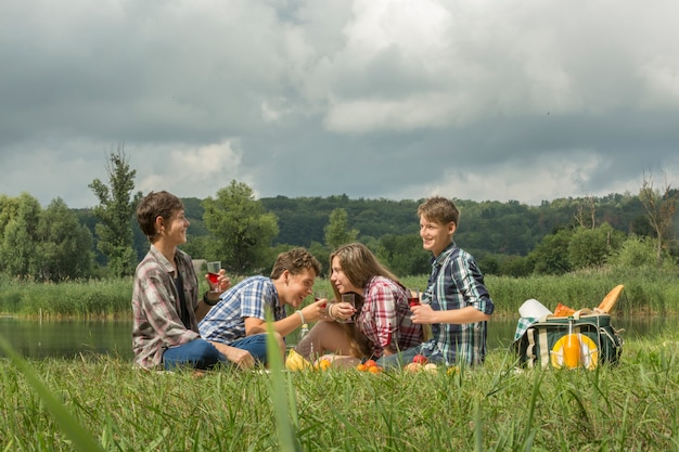 Groep vrienden met een picknick in de buurt van de rivier