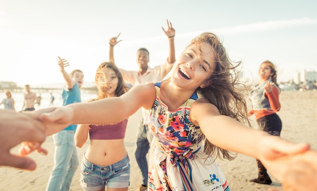 Groep vrienden plezier hebben en dansen op het strand