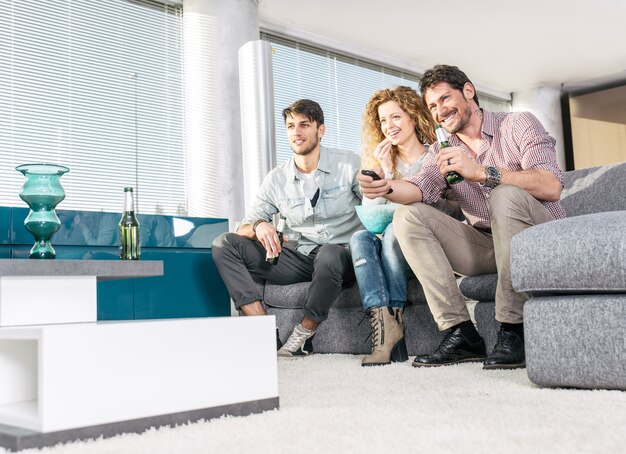 Groep vrienden televisie kijken in de woonkamer