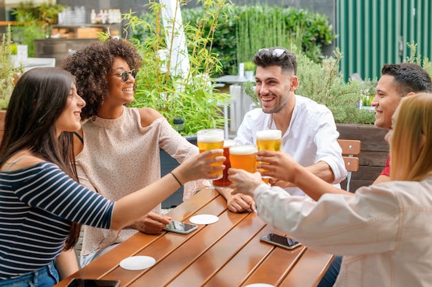 Groep vrienden vieren in een openluchtrestaurant