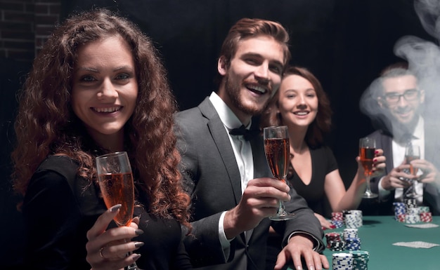 Groep vrienden zitten aan de speeltafel in casino