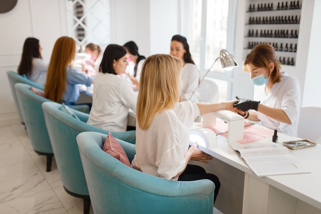 Groep vriendinnen ontspannen op manicure procedure in de schoonheidssalon.
