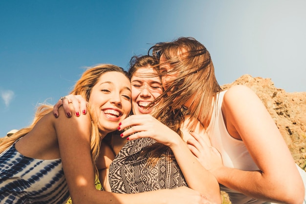 Groep vrij aardige jonge vrouwelijke vrienden die plezier hebben en veel lachen higging en glimlachen samen in vrijetijdsbesteding buitenshuis Meisjes en vriendschap levensstijl Zomervakantie vakantiedag