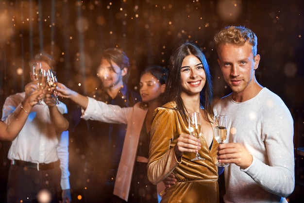 Groep vrolijke jonge mensen hebben feest en vieren het nieuwe jaar binnenshuis.