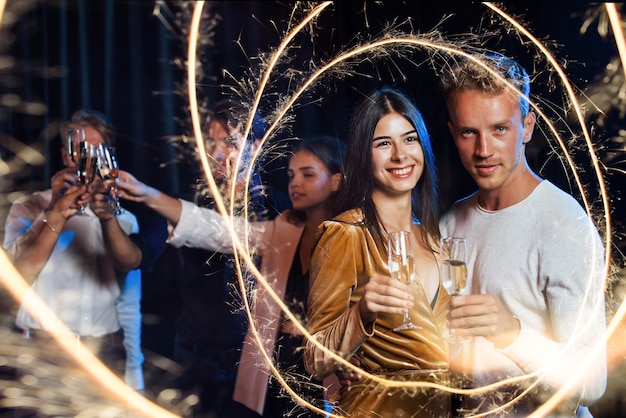 Groep vrolijke jonge mensen hebben feest en vieren het nieuwe jaar binnenshuis.