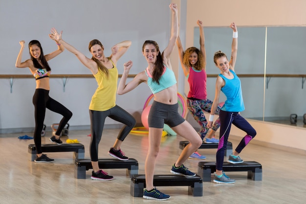 Groep vrouwen die op aërobe stepper uitoefenen