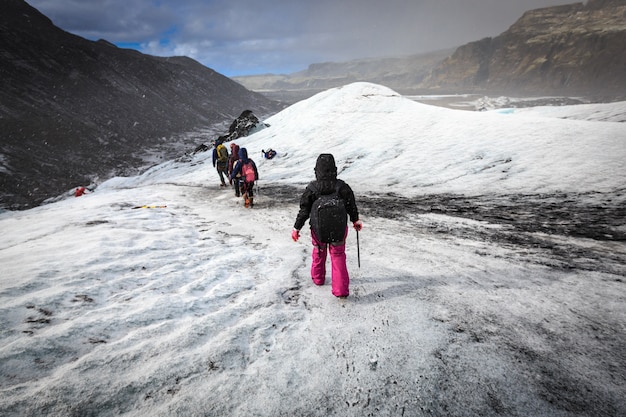 Groep wandelaar lopen op gletsjer tijdens zware sneeuwval op Solheimajokull