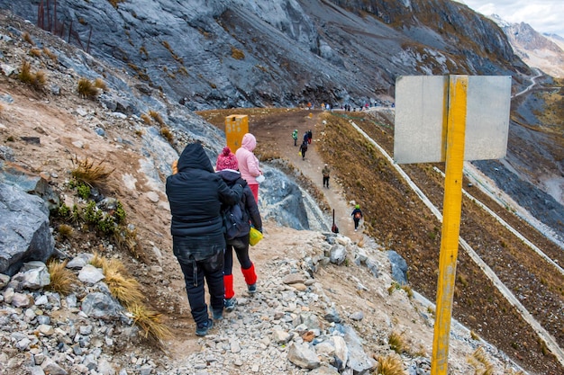 Foto groep wandelaars die een rots en een onverharde weg raura in oyon peru . afdalen