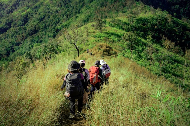 Groep wandelen met zware rugzaktas avontuurlijke trekking naar de top van de berg bij zonsondergang kan hemel Reisleven reizende levensstijl en sportactiviteit
