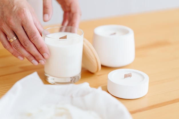 Groep witte kaarsen staan op houten tafel Women39s hHands met Ring Hold Candle Closeup