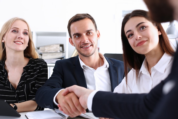 Groep zakelijke volkeren schudden handen als hallo in office close-up