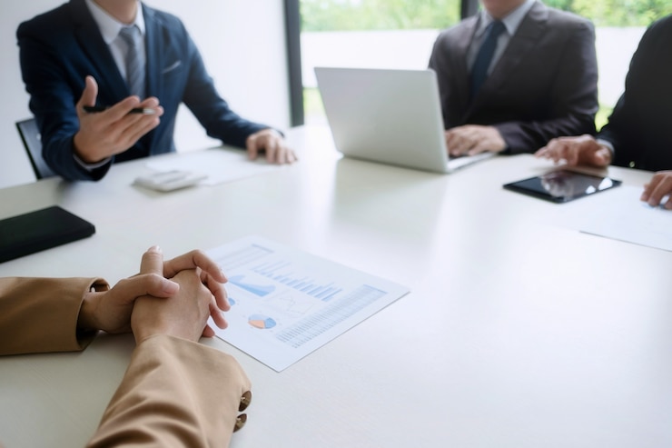 Groep zakenlieden bespreken waardering van onroerend goed met uitvoerend leider in een modern kantoor