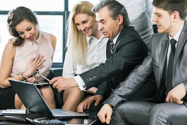 groep zakenlieden die het beleid van het bedrijf bespreken met behulp van een laptop