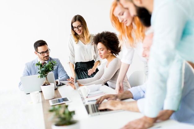 Groep zakenlieden en onderneemsters die in bureau samenwerken.