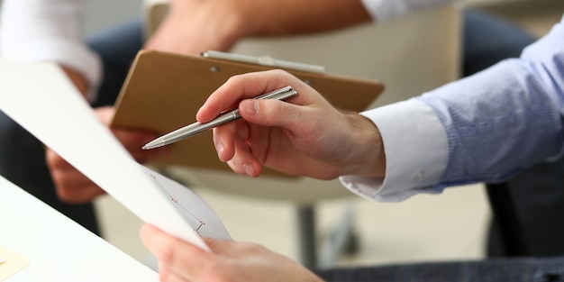 Groep zakenlieden met financiële grafiek en zilveren pen