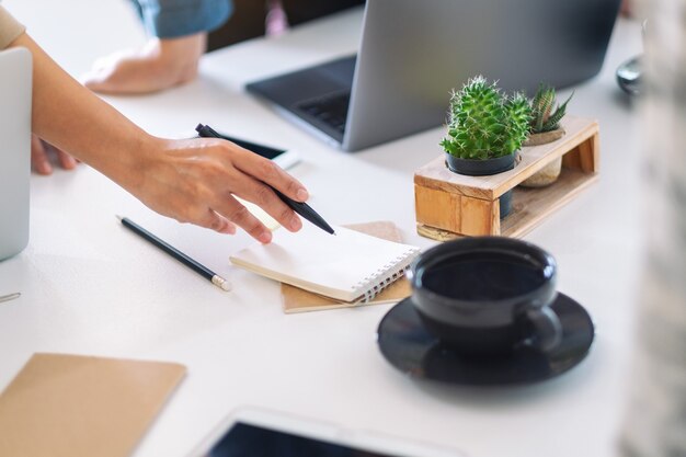 Groep zakenman die laptopcomputer gebruikt tijdens het bespreken en schrijven op notebook op tafel in kantoor