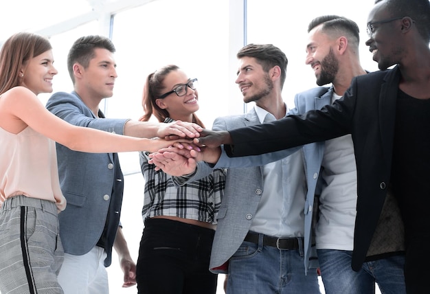 Groep zakenmensen die hun handen op elkaar stapelen op de werkplek