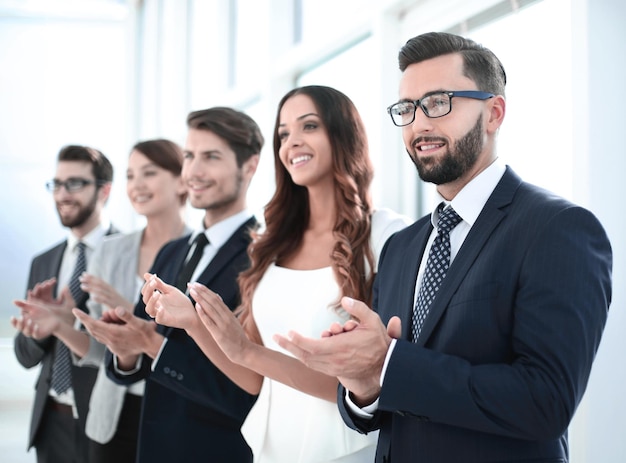 Groep zakenmensen die iemand applaudisseren die in het kantoorconcept van succes staat