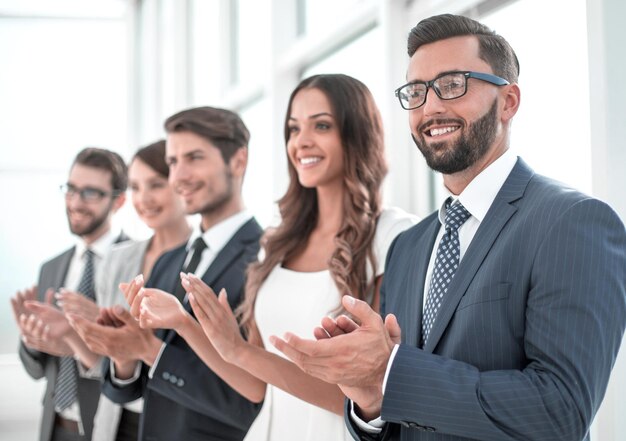 Groep zakenmensen die iemand applaudisseren die op kantoor staat