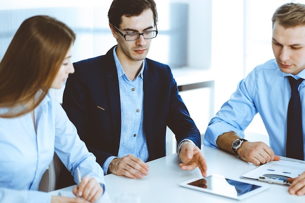 Groep zakenmensen die vragen bespreken tijdens een bijeenkomst in een modern kantoor. Managers bij onderhandeling of brainstorm. Teamwerk, partnerschap en bedrijfsconcept