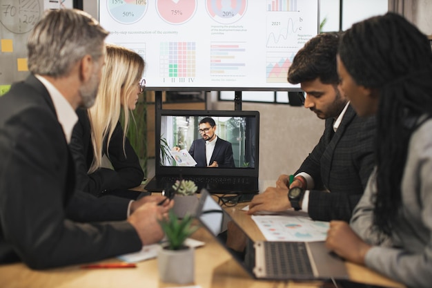 Groep zakenmensen met videoconferentie in directiekamer in modern kantoor