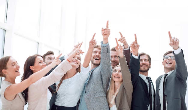 Groep zelfverzekerde jonge mensen die ergens naar boven wijzen