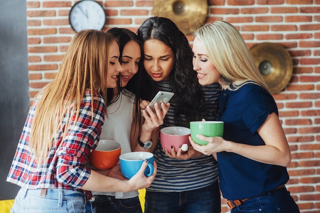 Groepeer mooie jonge mensen die in gesprek genieten van en koffie drinken, beste vriendenmeisjes die samen pret hebben, die emotionele levensstijl stellen