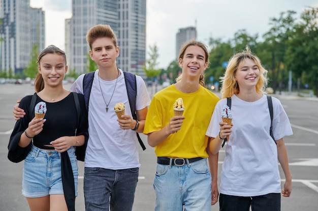 Groepsportret van gelukkige tieners die samen met ijs lopen