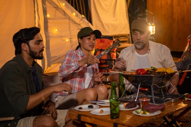 Foto groepstoeristen vrienden kamperen en barbecueën en bier drinken met feest samen met plezier en geluk in de zomer