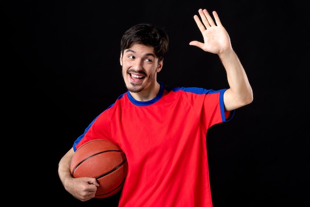 Groet mannelijke speler met basketbal op zwart