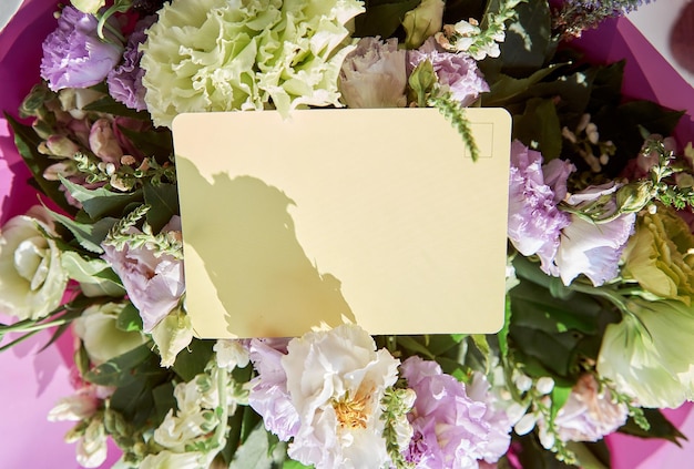 Groet mock up huidige postkaart met schaduwen in grote bloemen boeket van Eustoma Kopieer ruimte Bloemen leveringsconcept Hoge kwaliteit foto