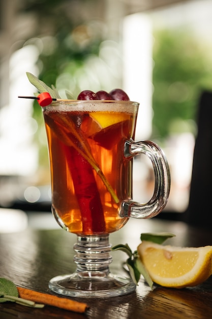 Grog. Warme drank voor winter of herfst. Pittige thee en rumcocktail met citroen, druif, kaneel en kruidnagel.