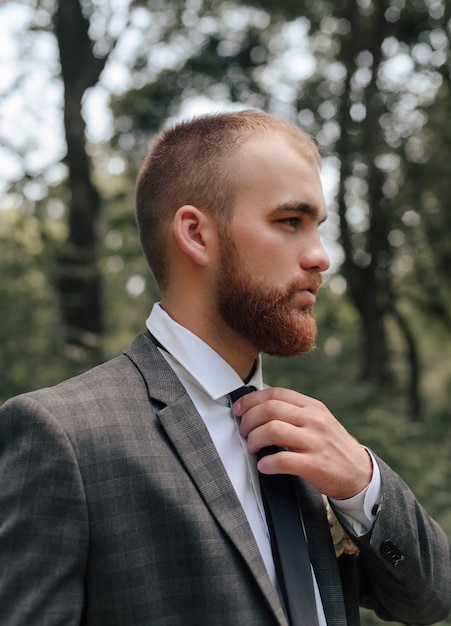 the groom adjusts his tie