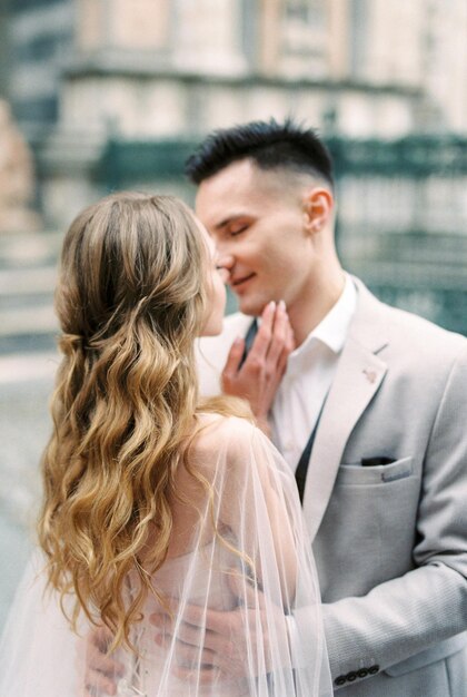 Groom almost kisses bride in front of the Basilica of Santa Maria Maggiore Bergamo Italy