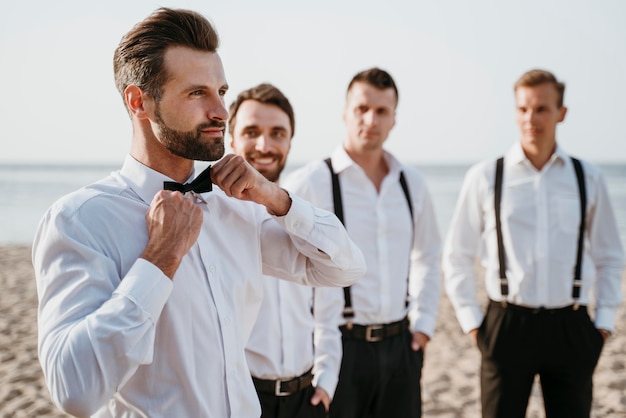 Photo groom and best men posing on the beach