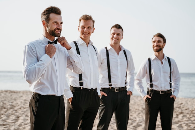 Photo groom and best men posing on the beach