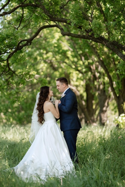 The groom and the bride are walking in the forest