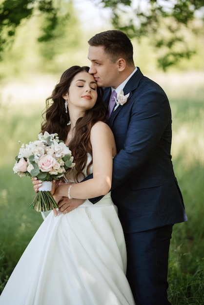 The groom and the bride are walking in the forest