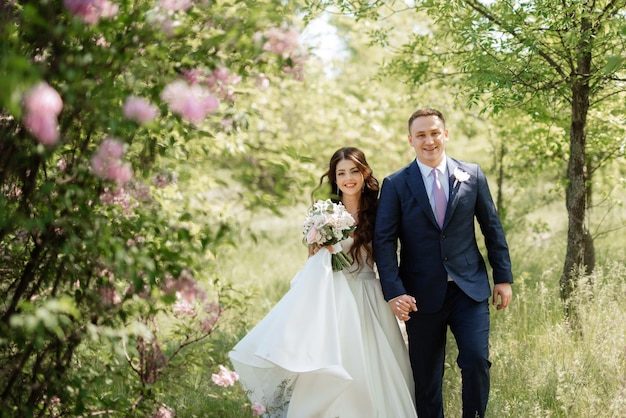 The groom and the bride are walking in the forest