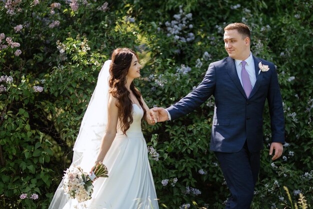 The groom and the bride are walking in the forest