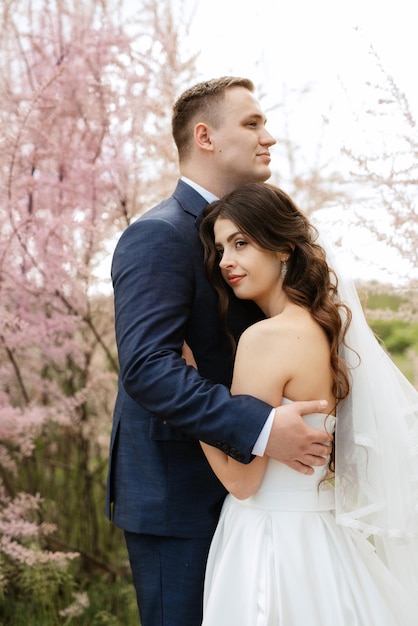 The groom and the bride are walking in the forest