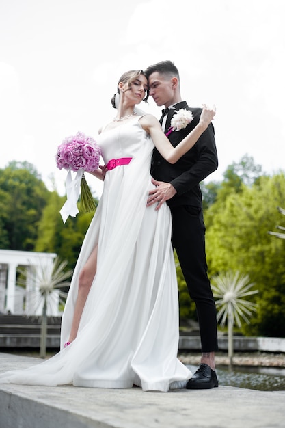 Жених и невеста позирует на открытом воздухе