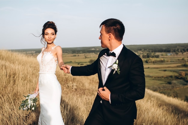 Groom and bride posing outside