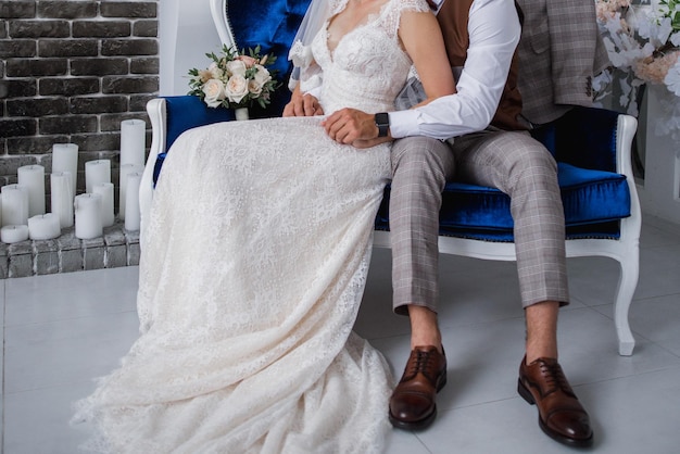 The groom and the bride sit together in a chair