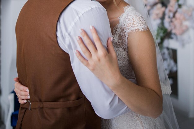 Groom and bride in the studio hugging together